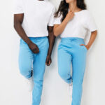 Couple souriant en t-shirts blancs et pantalons bleus