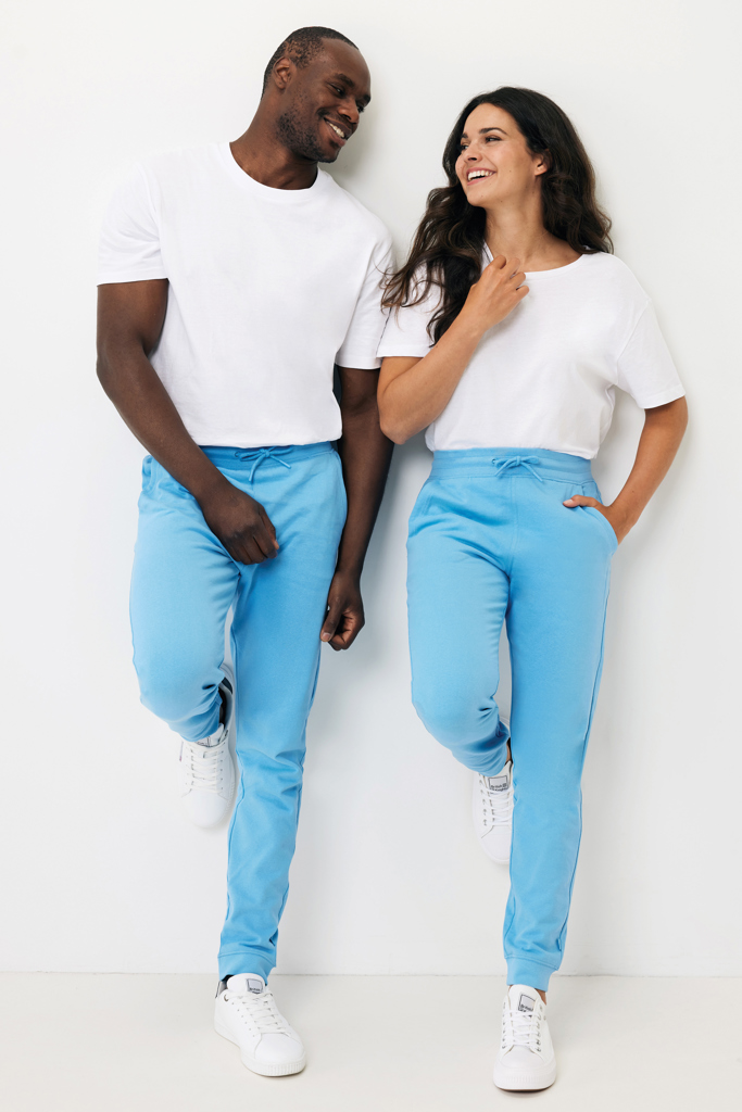 Couple souriant en t-shirts blancs et pantalons bleus