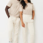 Couple en tenues beiges assorties sur fond blanc
