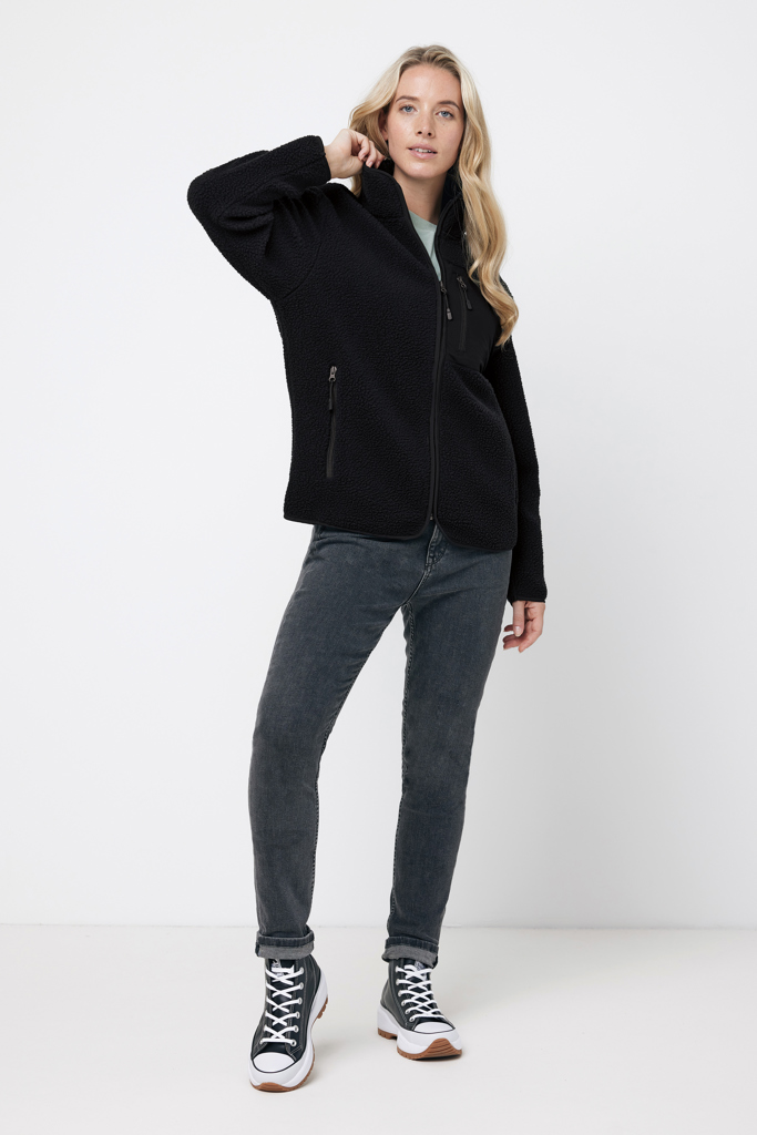 Femme portant veste polaire noire et jeans gris