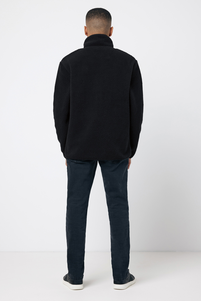 Homme de dos portant veste noire et jean