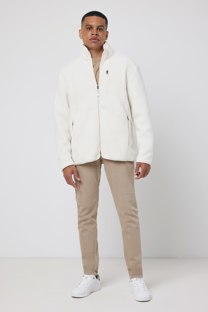 Homme portant veste polaire blanche et pantalon beige
