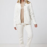 Femme portant veste polaire crème et pantalon blanc