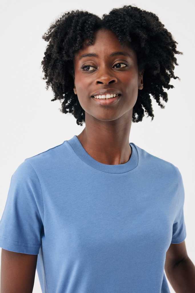 Femme souriante aux cheveux bouclés en t-shirt bleu