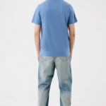 Homme de dos en t-shirt bleu et jean clair