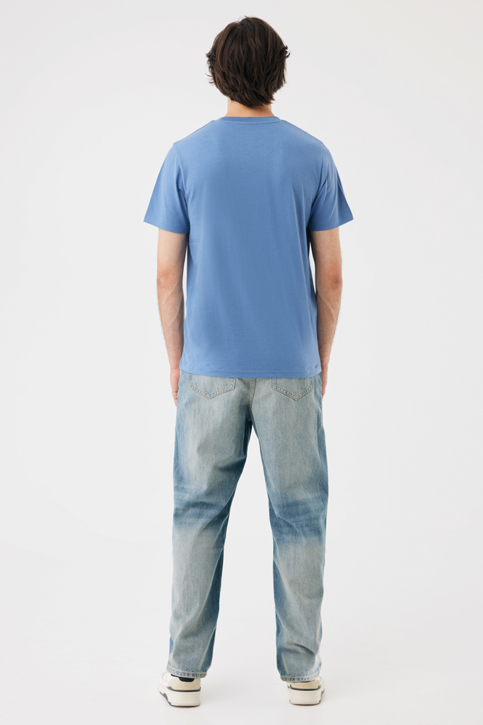Homme de dos en t-shirt bleu et jean clair