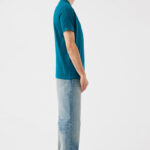 Homme debout de profil en t-shirt bleu