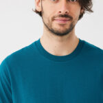 Portrait d’homme brun en t-shirt bleu pétrole