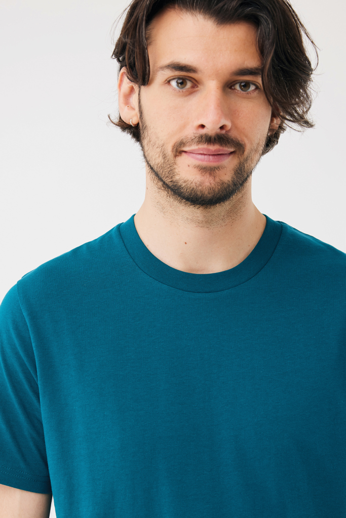 Portrait d’homme brun en t-shirt bleu pétrole