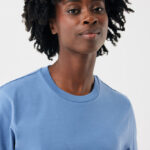 Portrait femme aux cheveux bouclés en t-shirt bleu