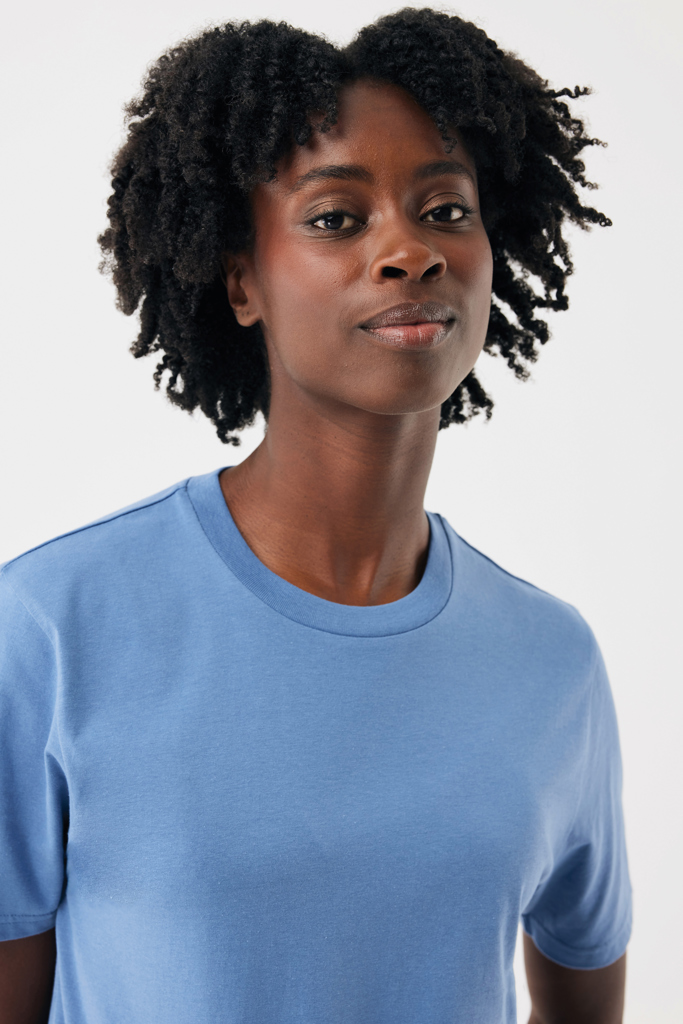Portrait femme aux cheveux bouclés en t-shirt bleu