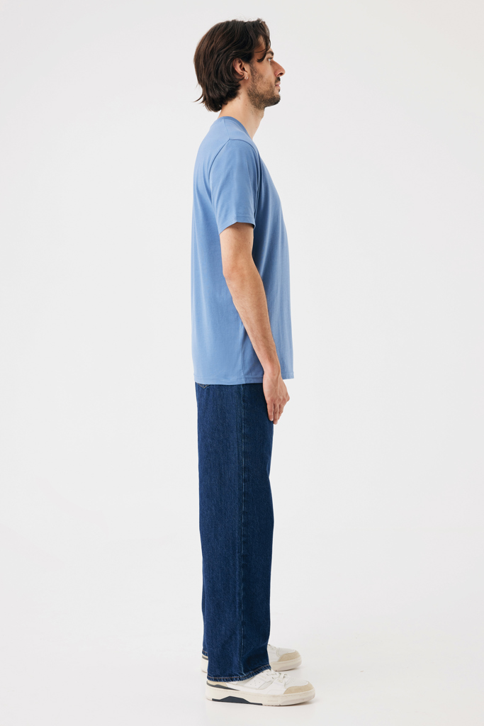 Homme debout de profil en t-shirt bleu