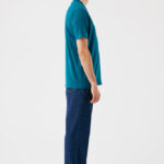 Homme debout de profil en t-shirt vert