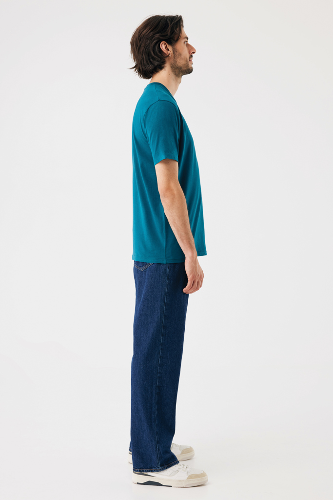 Homme debout de profil en t-shirt vert