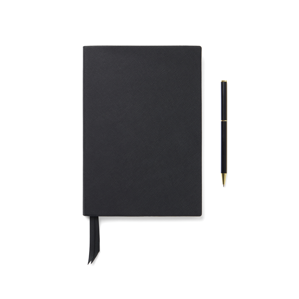 Carnet noir avec stylo assorti sur fond blanc