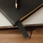 Carnet noir avec stylo sur bureau en bois