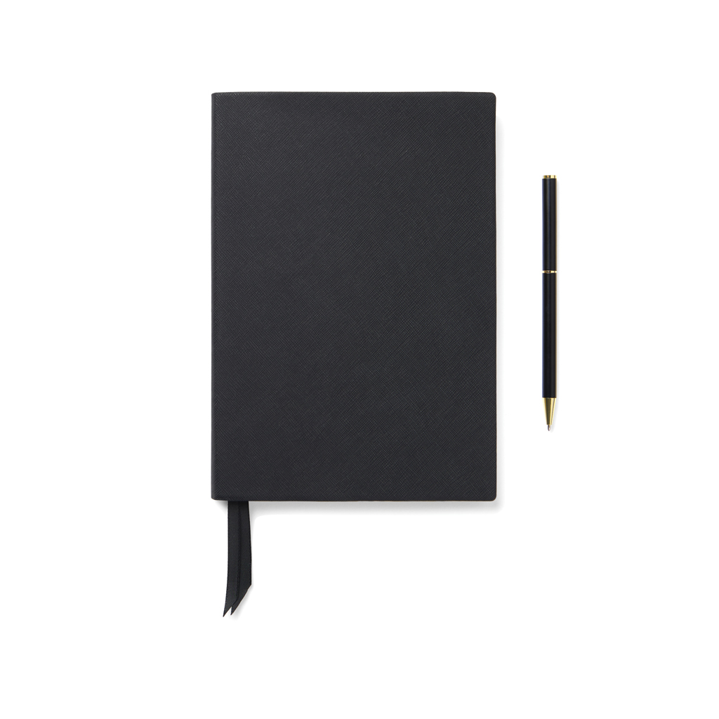 Carnet noir avec stylo sur fond blanc
