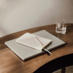 Ordinateur portable, carnet et verre d’eau sur bureau