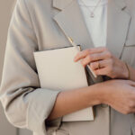 Femme élégante tenant carnet et stylo beige