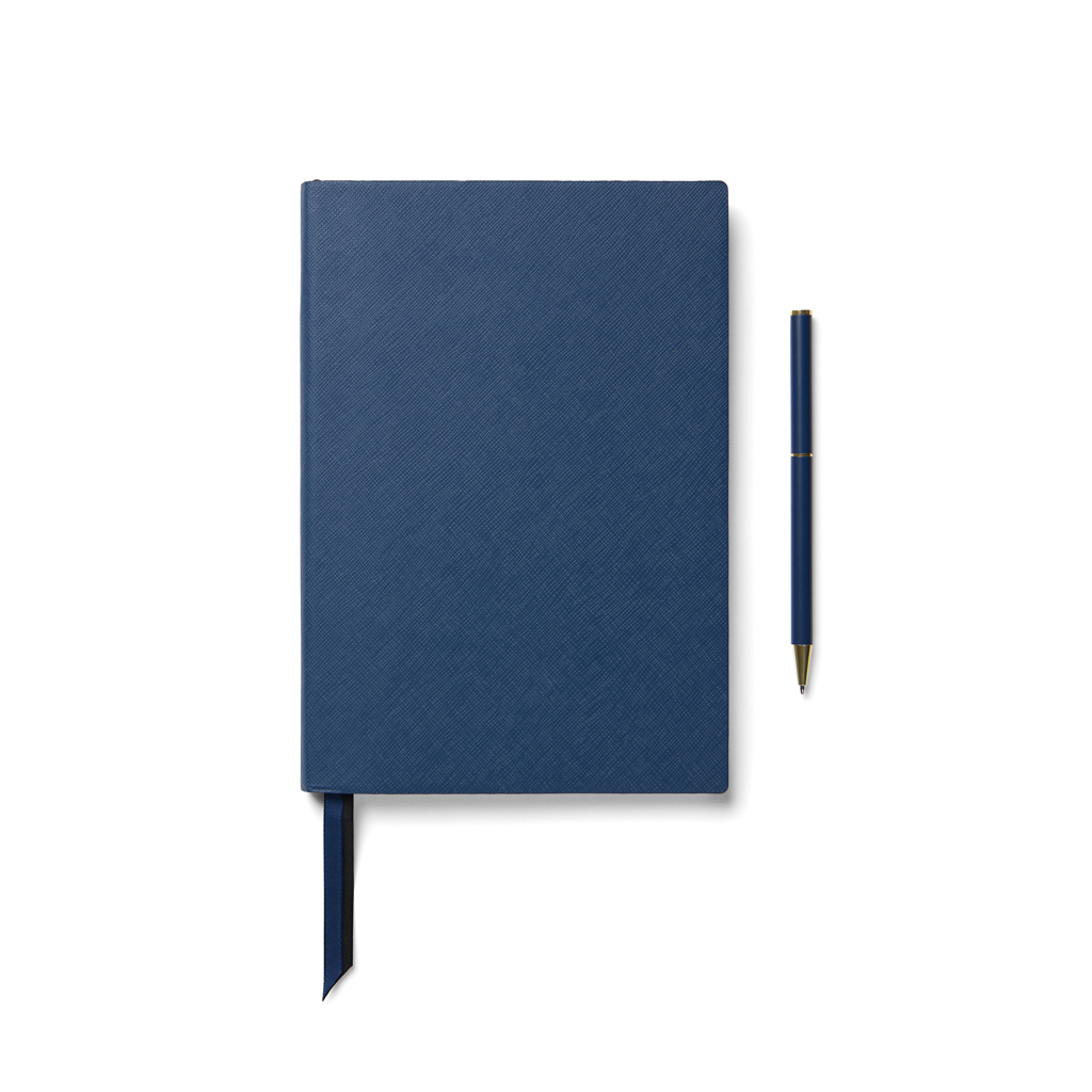 Carnet bleu avec stylo assorti sur fond blanc