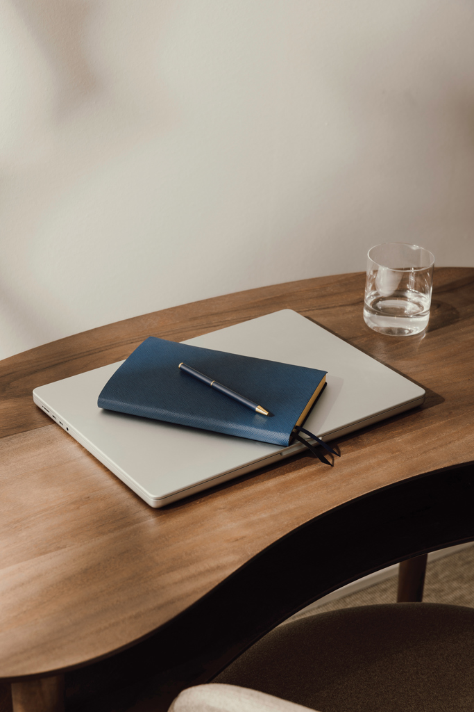 Ordinateur portable et carnet sur bureau en bois