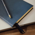 Carnet bleu avec stylo sur ordinateur portable