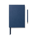Carnet bleu avec stylo assorti sur fond blanc